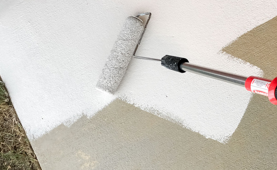 Painting concrete using a roller for the concrete staining technique.