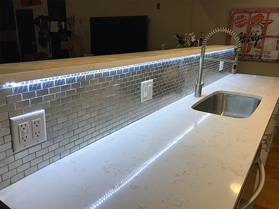 Kitchen counter with a sink, featuring stainless steel fixtures